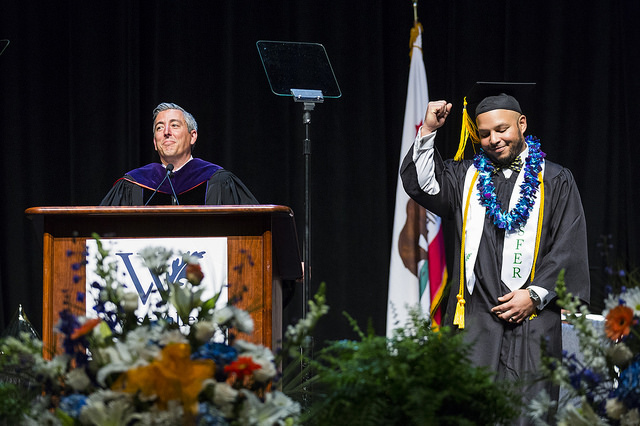 Transfer student on stage with president during graduation ceremony